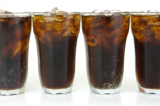 Glasses of cola isolated against a white background