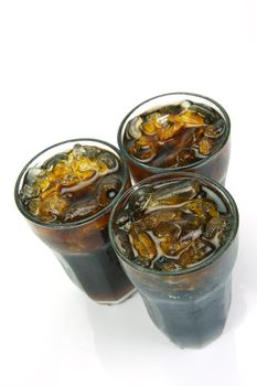 Glasses of cola isolated against a white background