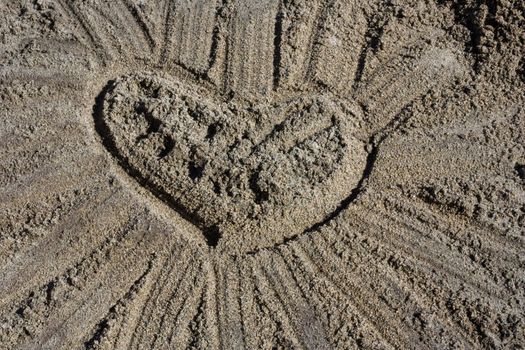 lovely heart with rays  on beach sand