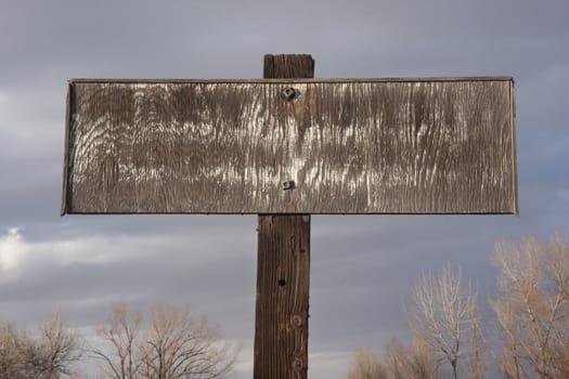 old faded rectangular plywood private propery sign against cloudy sky