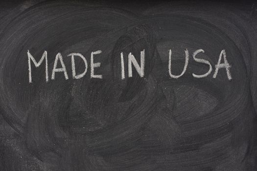 made in USA phrase handwritten with white chalk  on a blackboard with eraser smudges and copy space below