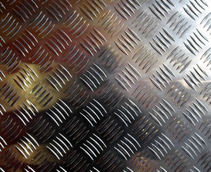 Diamond steel plate industrial iron metal background with yellow light reflection