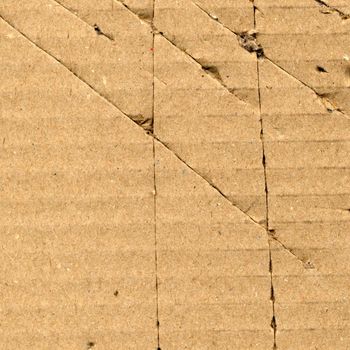 Brown torn corrugated cardboard sheet background with cuts