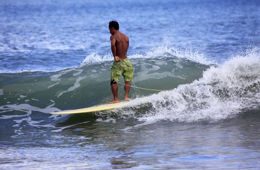 Young men - the surfer in ocean. Bali. Indonesia