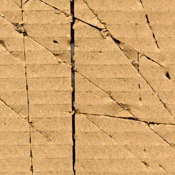 Brown torn corrugated cardboard sheet background with cuts