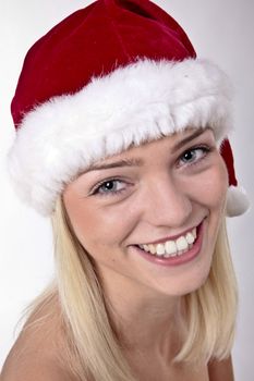 Closeup Portrait Of A Sweet Blond Girl Wearing A Santa Hat