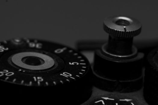 Old analog photo camera in black background