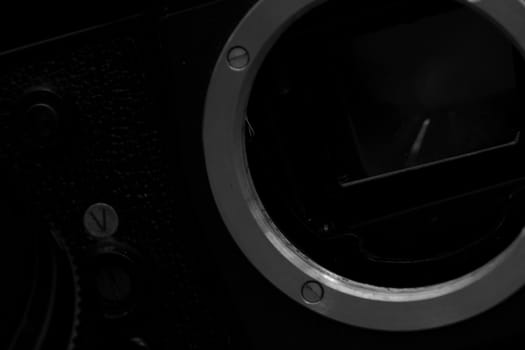 Old analog photo camera in black background