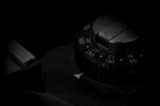 Old analog photo camera in black background