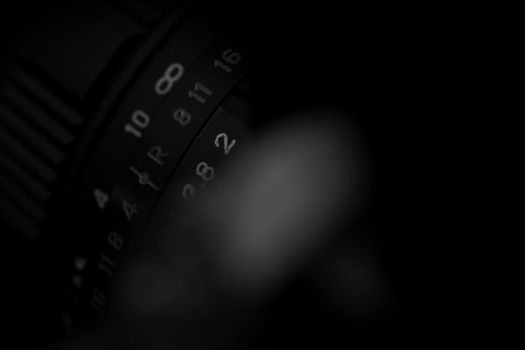 Old analog photo camera in black background