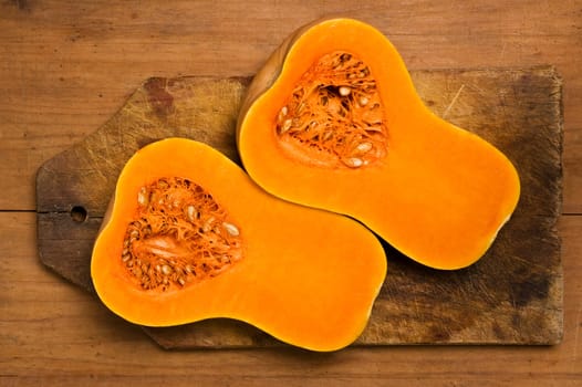 Two slices of pumpkin on a wooden kitchen table.