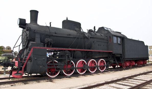 Steam locomotive beside a railway station platform. Retro train.