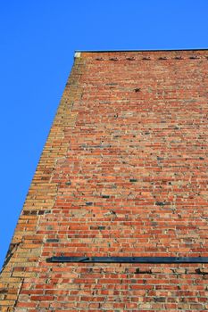 Brickwall over blue sky showing unique pattern.
