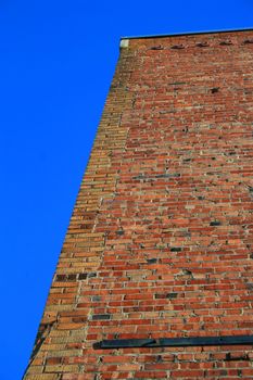 Brickwall over blue sky showing unique pattern.
