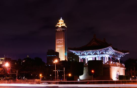 A modern city skyscraper and traditional chinese building in the night.