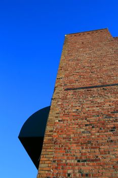 Brickwall over blue sky showing unique pattern.
