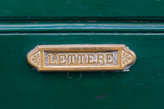Old brass letterbox on a green door