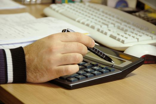 man fingers over gray calculator buttons closeup