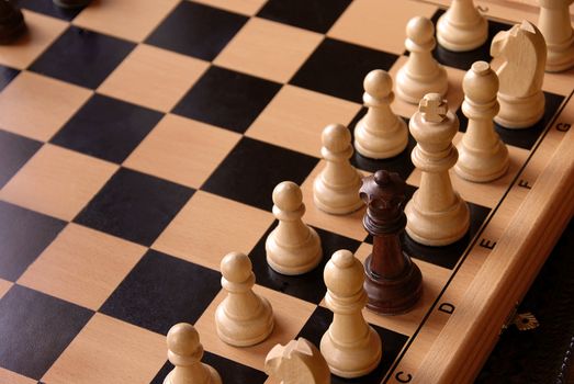 chessboard with black queen  among white figures