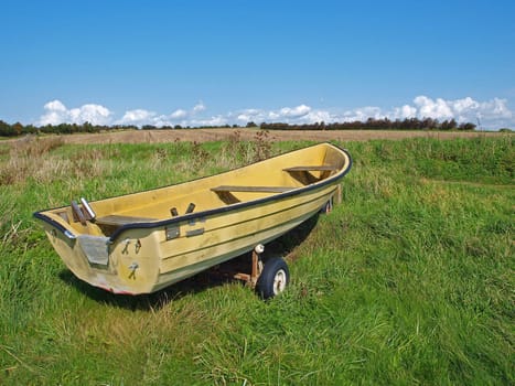 Small fishing Skiff boat on the seashore green field