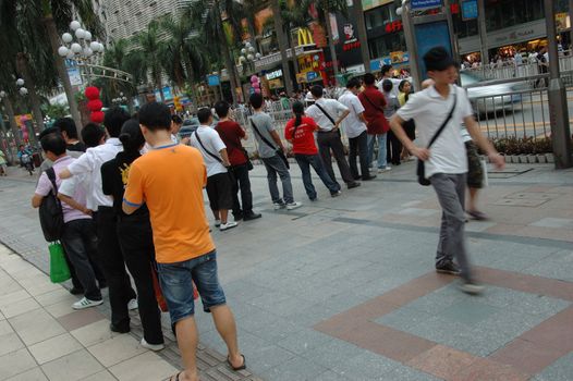 CHINA, SHENZHEN - AUGUST 20: overpopulated city in Guangdong province. Crowd of people waits in queue and pushes to the buses after work.