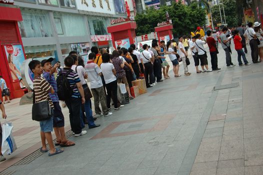 CHINA, SHENZHEN - AUGUST 20: overpopulated city in Guangdong province. Crowd of people waits in queue and pushes to the buses after work.