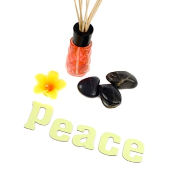 Concept of peace by using a scented flower candle and aroma reeds, along with some relaxing stones, isolated against a white background
