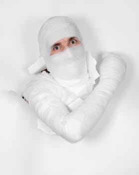 Boy in bandage put out from hole in white paper