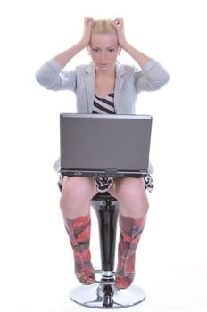 Beauty woman sits with a laptop on knees and sticks to two hands for a head