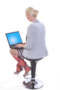 Beauty woman sits with a laptop on knees isolated on white. View from back.