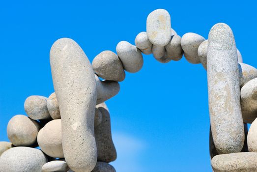 Sea pebble combined in the form of the bridge against the sky