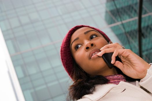 An attractive business woman talking on her cell phone in the city.