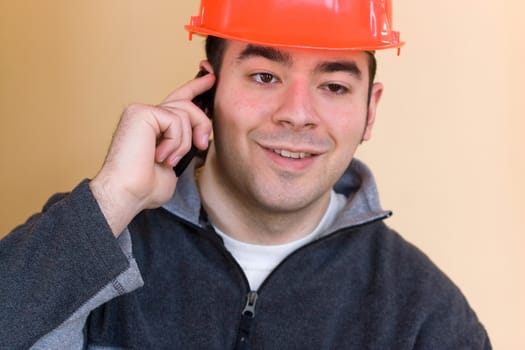 A young construction professional talks on his smartphone.