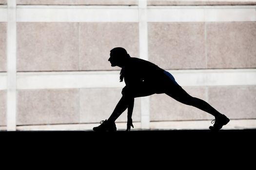 Single woman stretches before she goes for run.
