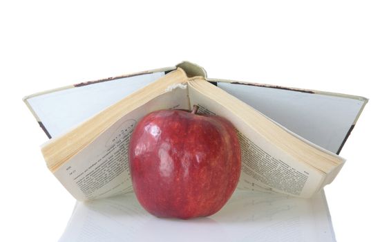 Red apple on book isolated on white