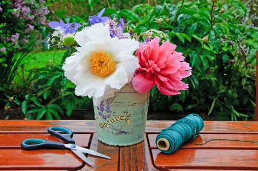 Making flower bouquets of peonies in the garden.