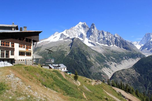 Cable car arriving at the Flegere station mountain in front of the Mont-Blanc massif by beautiful weather, France