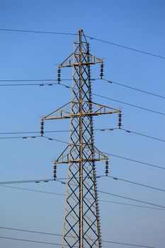 Electrical pylon by sunset and deep blue sky