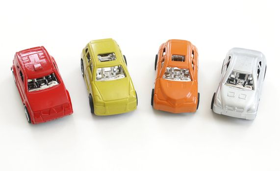 Four different colored toy cars in a row.