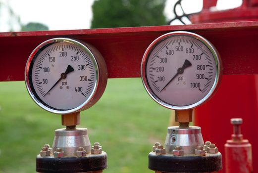 Two similar pressure gauges on heavy equipment