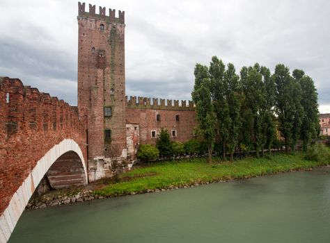 Ponte CastelVecchio in Verona with battlements against the cloudy sky