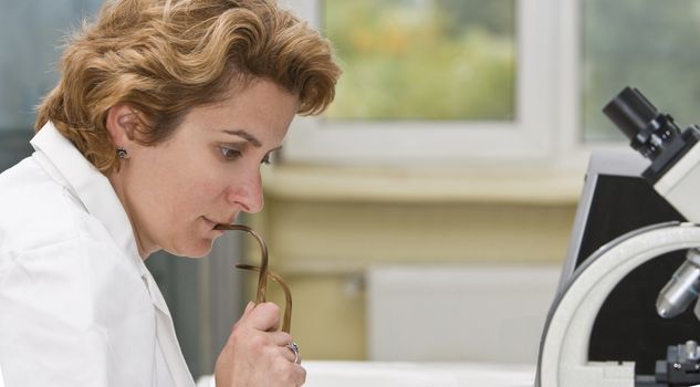 Female researcher thinking at his workplace.