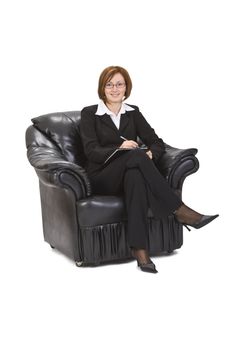 Smiling businesswoman sitting in an armchair and writing something on a wallet.