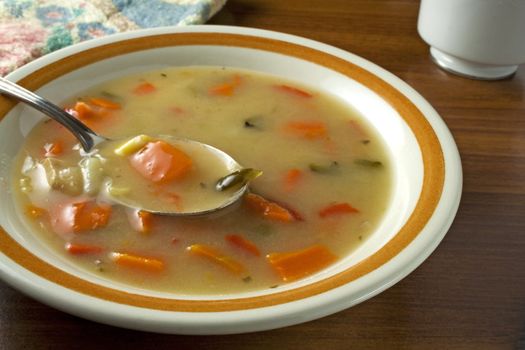 Chicken vegetable soup in bowl with spoon