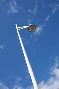 Low-angle view of a lamp post with a blue sky