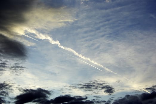 It's a very nice double traces of airplane in the morning sky with some evanescent clouds