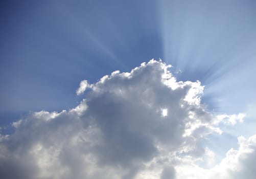 Big rays of sunlight through clouds