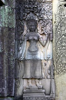 Detail of an engraving women on a wall of an Angkor temple