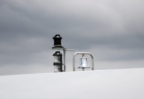 Chromed bell of a yacht with a cloudy sky in the background