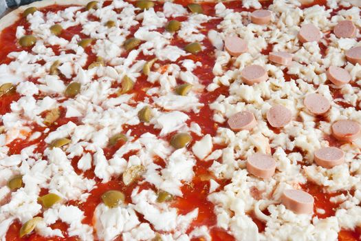detail of raw pizza with tomato mozzarella olives and wurstel